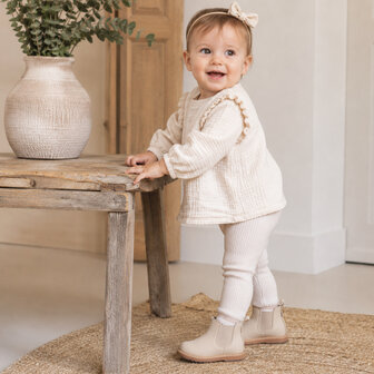 Baby van ongeveer 12 maanden met beige Chelsea enkellaarsjes
